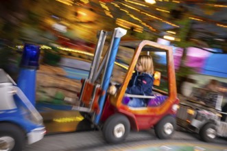 Boy, 5 years, blond, in children's carousel, carousel, movement, wiping effect, carnival, spring