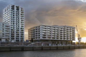 Modern residential building on Strandkai, Historic crane, Dramatic clouds, Überseequartier,