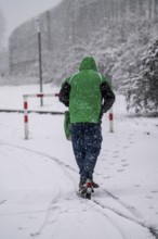 Winter weather, heavy snowfall, city centre traffic, man on e-scooter in driving snow, Essen, North