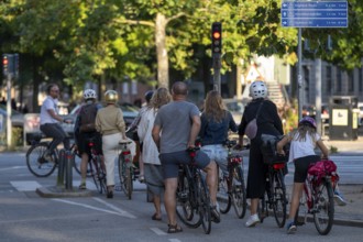 Group of people on bicycles waiting at a red traffic light in an urban environment, Copenhagen,