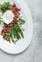 Asparagus with poached egg and fried bacon, micro greens and spices, breakfast, homemade, no people