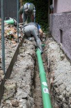 Construction worker, newly laid green sewage pipe, trench, Stuttgart, Baden-Württemberg