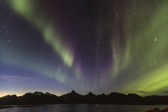 Northern Lights, Aurora borealis over a fjord with steep mountains, autumn, Tasiilaq, East