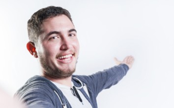 Happy young man welcoming you isolated. Portrait of smiling guy inviting to come