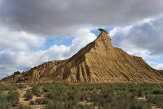 Lonely hilltop with characteristic shapes rises magnificently under a partly cloudy sky in the