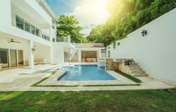 Beautiful crystal clear swimming pool in a backyard. Swimming pool surrounded by nature trees