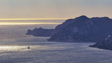 View of a coastal landscape at sunset with ships on the sea and mountains in the background, Cape