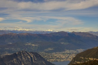 Aerial View over Beautiful Mountainscape with Snow Capped Mountain and Lake Lugano and City of