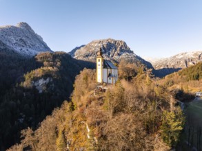 Church on a hill with snow-covered mountains in the background at sunrise, St Pankraz, Karlstein,