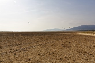 Sandy beach beach Playa de los Lances, kite surfers and walkers on the horizon, Tarifa, Strait of