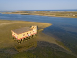 Lonely building on stilts on the shore of a sandy beach with a quiet atmosphere in summer weather,