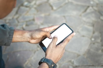 Hands of person using phone, showing blank screen