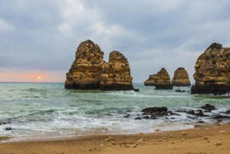 Rocky coast with beach and red rocks, Praia do Camilo, Lagos, Algarve, Portugal, Europe