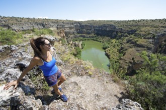 Castilian woman, 48 years old, looking at the gorge and the river Duratón, canoes on the water, on