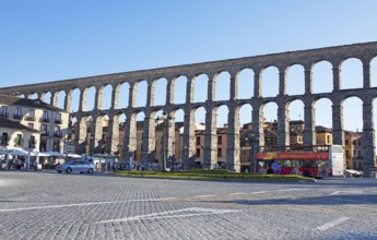 Sightseeing bus at the Roman aqueduct in Plaza de Azoguejo, Segovia, province of Segovia, Castile