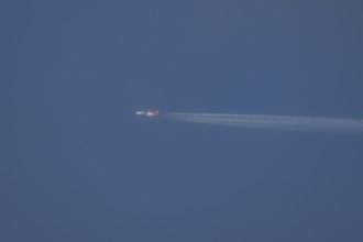 Boeing 747 jumbo jet aircraft in flight with a contrail or vapour trail in the sky, England, United