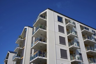 Modern residential building with several balconies and a façade under a clear blue sky, Molde,