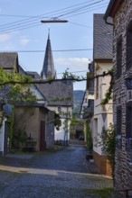 Alley, historic buildings, church tower of St. Nicholas, pointed roofs with slate slabs, lamp,