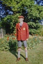 Boy standing in the garden wearing a brand new school uniform, England, Great Britain, 1960s,