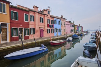 Colorful houses beside the waterway at 'Fondamenta Cao di Rio a Sinistra' with boats lying in the