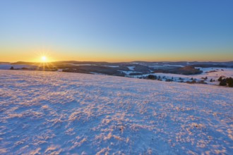 Snow-covered landscape at sunrise lying gently over the hills, winter, Wasserkuppe, Gersfeld, Rhön,