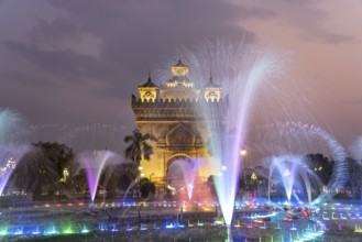 Colourfully illuminated fountain at Patuxai Victory Gate at dusk, capital Vientiane, Laos, Asia