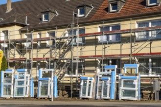 Energy-efficient refurbishment of residential buildings, older apartment block is scaffolded, gets