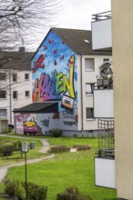 Housing estate, apartment buildings, colourful mural with local reference, music, 99 balloons, in