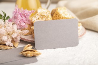 Gray business card with traditional turkish delight (rahat lokum) on white ceramic bowl on a gray