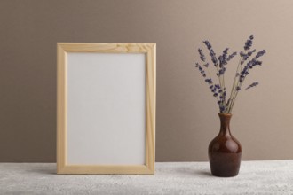 White wooden frame mockup with lavender in ceramic vase on beige paper background. Blank, vertical