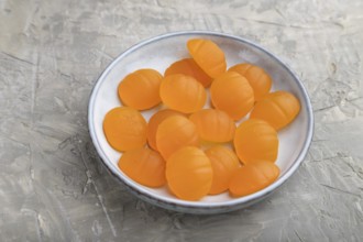 Jelly pumpkin candies on gray concrete background. close up, side view. autumn concept