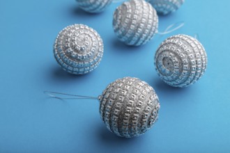 Christmas or New Year composition. Decorations, silver balls, on a blue paper background. Side