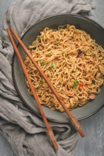 Instant noodles, in a bowl, on a gray table, top view, no people