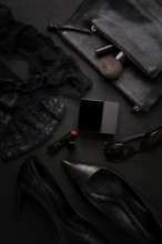 Women's accessories, black heeled shoes, cosmetics, underwear, top view, on a black background,