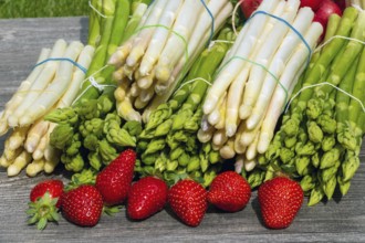 Green asparagus, white asparagus and fresh strawberries decorated on a rustic wooden table