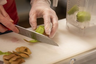 Wheat Ridge, Colorado, Joshua Hudson peels kiwi fruit to make a smoothie at his Twisted Smoothie