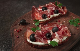 Sandwich with cream cheese, prosciutto with olives, breakfast