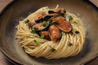 Spaghetti with mussels, without shell, pasta with peeled mussels, in carbonara sauce, micro-greens,