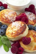 Breakfast, cottage cheese cakes, with fresh berries, and sour cream, top view, close-up, no people