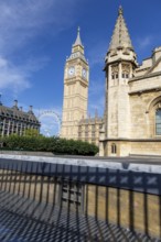 Big Ben and another historic building under a clear blue sky in London, United Kingdom United