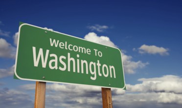 Welcome to washington green road sign over blue sky with some clouds