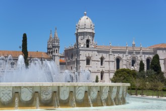 Eine gotische Kathedrale mit imposanten Türmen und einem verzierten Brunnen davor, unter einem