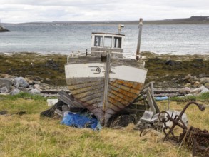 Derelict fishing boat on the shore of the Arctic Ocean, at the edge of the fishing village of