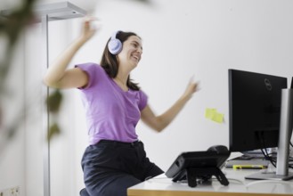 A woman dances at her workplace in Berlin, 08/08/2024