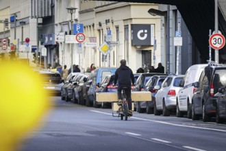 A man rides a cargo bike loaded with parcels on a street in Berlin Mitte. Berlin, 30.01.2024