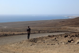 Lone man walking in barren landscape Jandia peninsula, Fuerteventura, Canary Islands, Spain, Europe