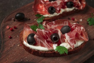 Sandwich with cream cheese, prosciutto with olives, breakfast