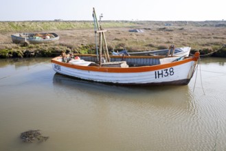 Small fishing boats moored in tidal inlet on the River Alde at Slaughden, Aldeburgh, Suffolk,