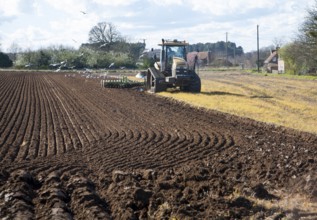 Challenger tracked tractor ploughing and pressing the soil in an arable field, Butley, Suffolk,