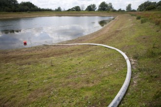 Irrigation pipe water reservoir lake at low level in summer Sutton, Suffolk, England, UK